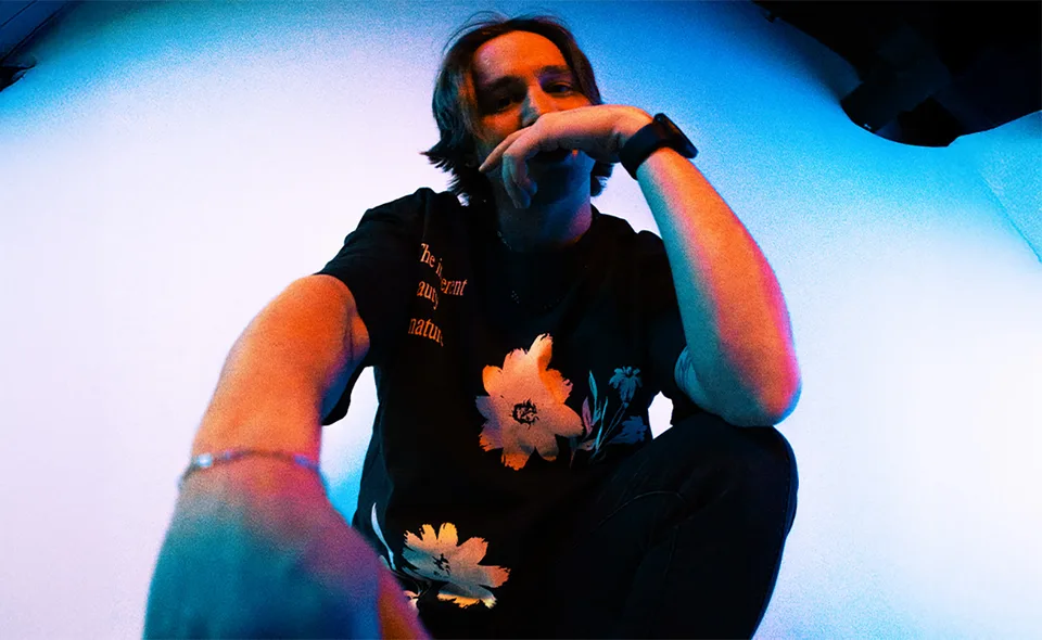 AG holding a microphone in a low-angle performance photograph.
