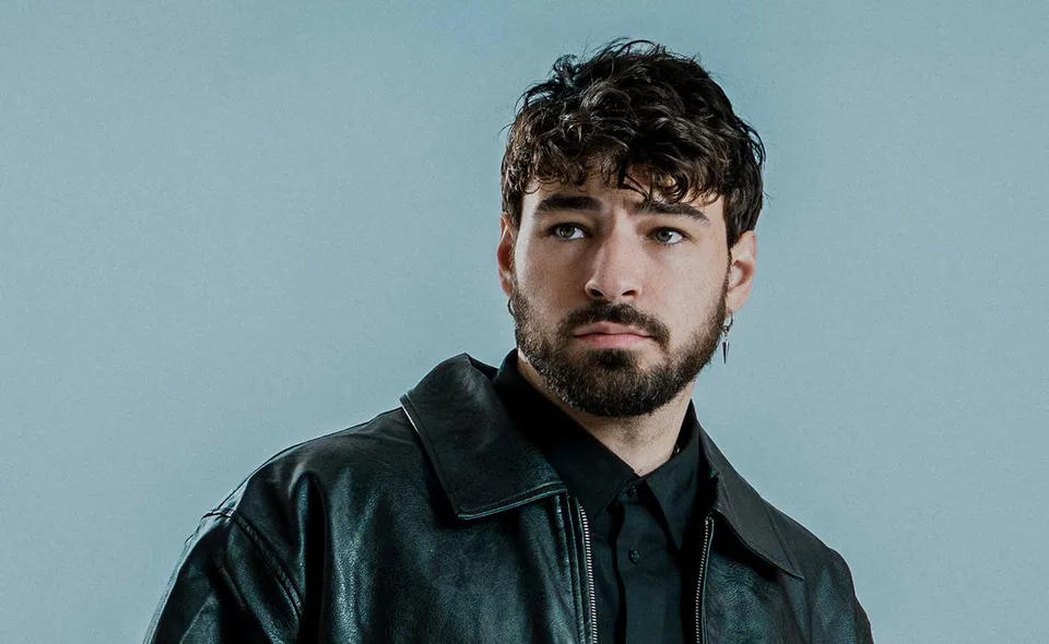 Crankdat in a dark leather jacket against a grey-blue background.