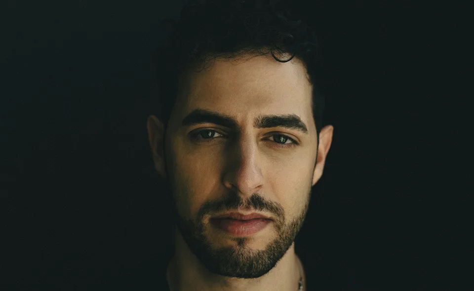A close-up portrait of Jason Ross against a dark background.