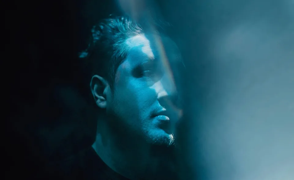 Nurko in profile under layered blue light.