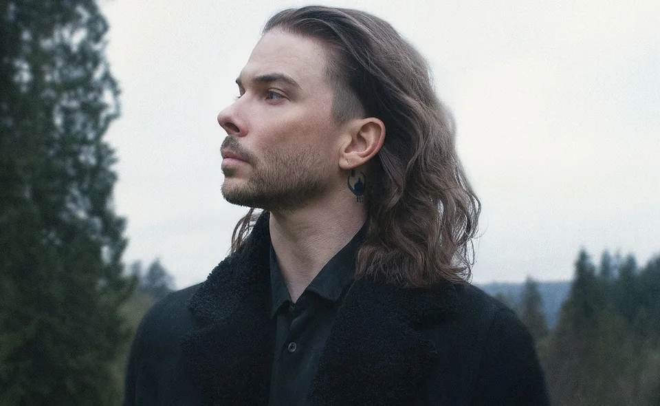 Seven Lions in profile outdoors, with long hair and a dark jacket.