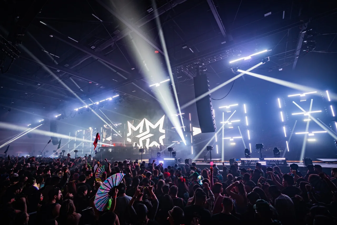 Bright white beams above the Give Thanks 2025 stage and audience.